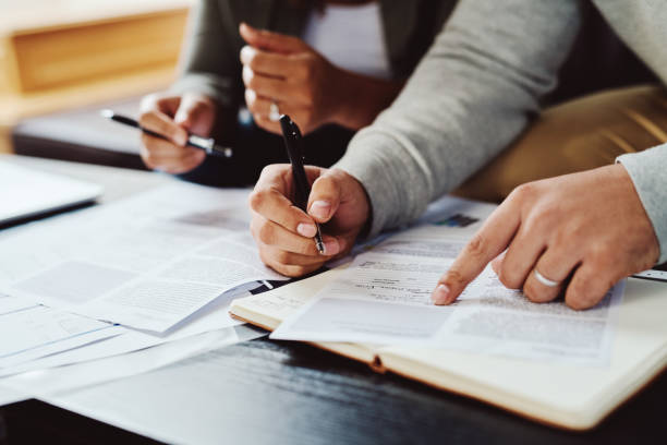 Closeup shot of an unrecognizable couple going through paperwork together at home